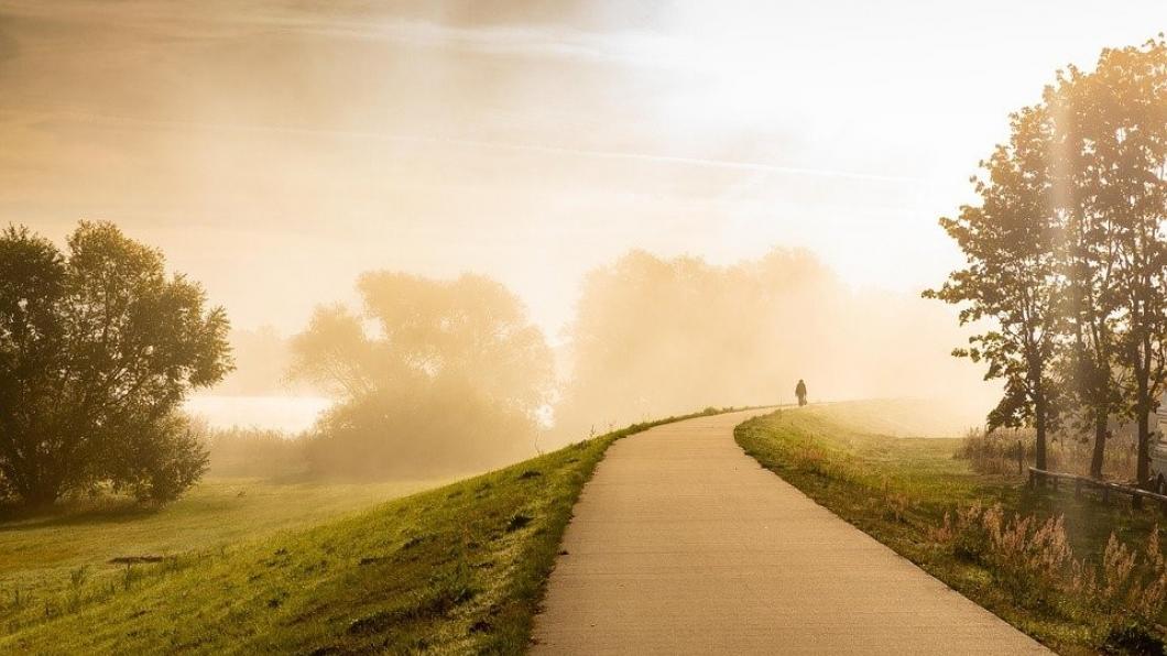Een dijk met aan het einde van de weg een fel licht.